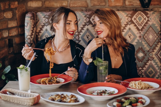 Due donne che mangiano pasta in un ristorante italiano