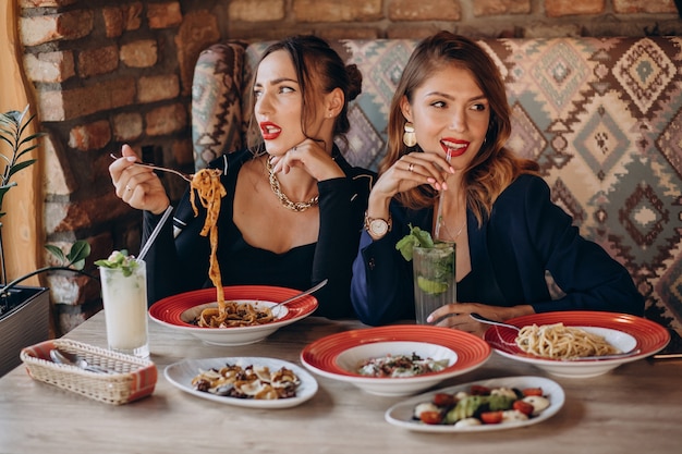 Due donne che mangiano pasta in un ristorante italiano