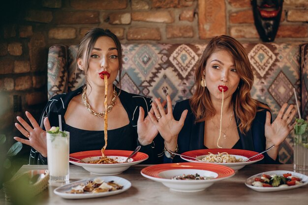 Two women eating pasta in an italian restaurant