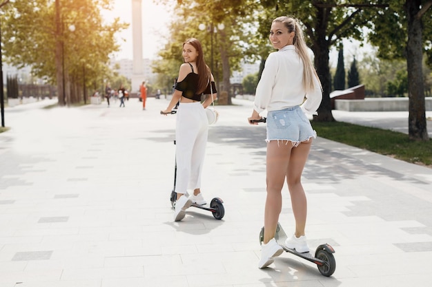 two women friends with electro scooter