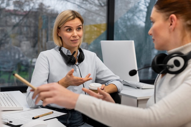 Due donne che hanno una conversazione durante il lavoro nell'ufficio del call center