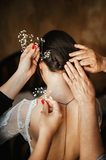 결혼식을 준비하는 동안 신부를 돕고 머리에 꽃을 꽂는 두 여성