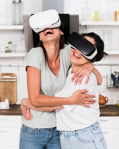 Two women at home having fun with virtual reality headset