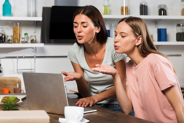 Two women at home video chatting on laptop