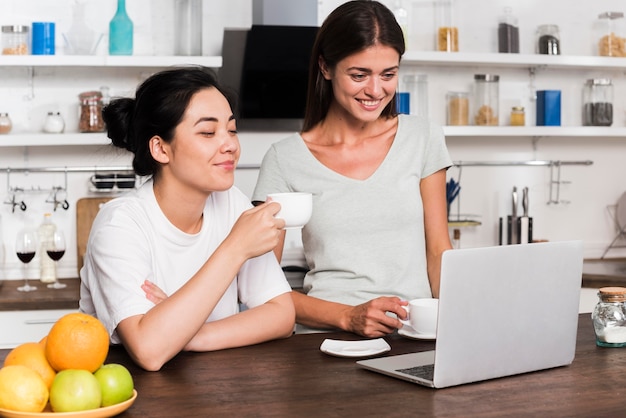 Free photo two women in the kitchen at home chatting over coffee