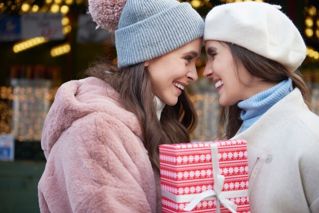 Two women in love  holding one Christmas gift