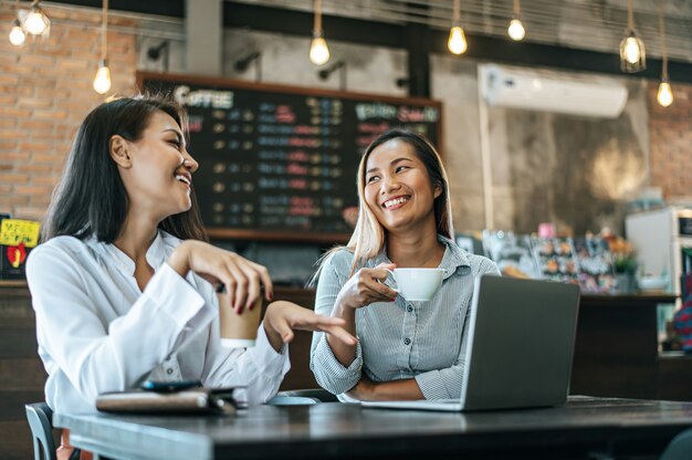 座っているとコーヒーショップでラップトップで働く2人の女性