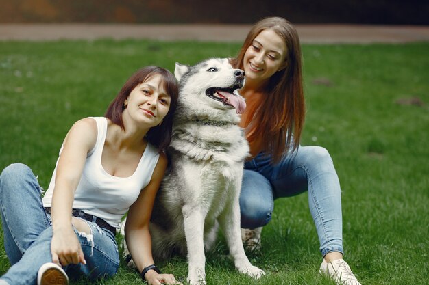 春の公園でかわいい犬と遊ぶ2人の女性