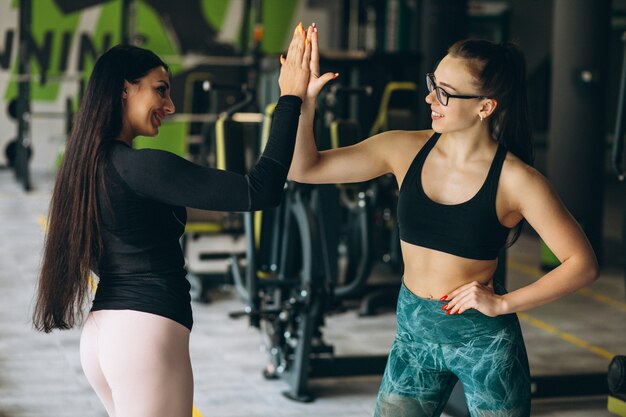 Две женщины тренируются вместе в тренажерном зале
