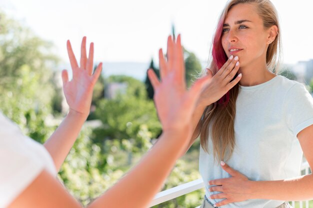 Two women using sign language to communicate outdoors