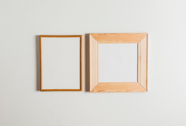 Two wooden frames hanging on white wall