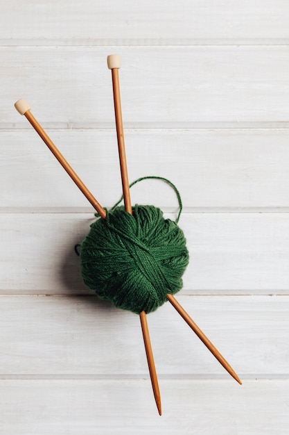 Two wooden needles in ball of wool