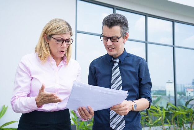 Two worried business partners angry with financial report. 