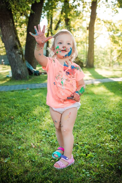 緑の芝生に対して色に染まった2歳の女の子