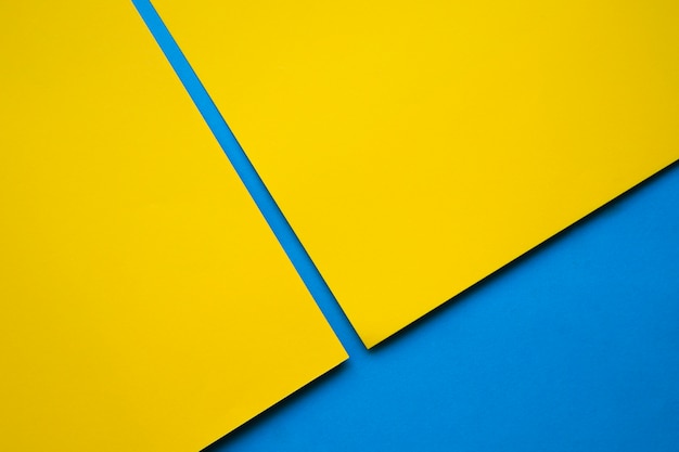 Two yellow craftpapers on blue surface