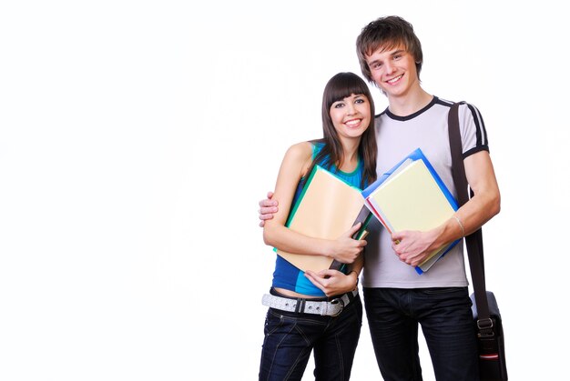 Two young adult students standing and embracing isolated on white