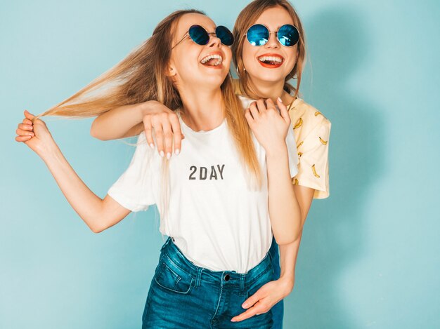 유행 여름 화려한 티셔츠 옷에 두 젊은 아름 다운 웃는 금발 hipster 여자.