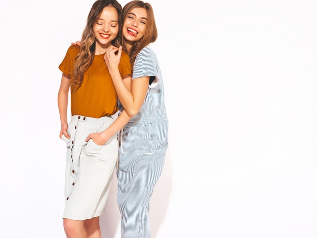 Две молодые красивые улыбающиеся девушки в модной летней повседневной одежды. Сексуальные беззаботные женщины. Позитивные модели