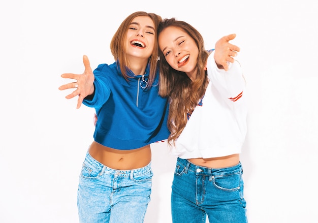 Two young beautiful smiling girls in trendy summer clothes. carefree women. Positive models