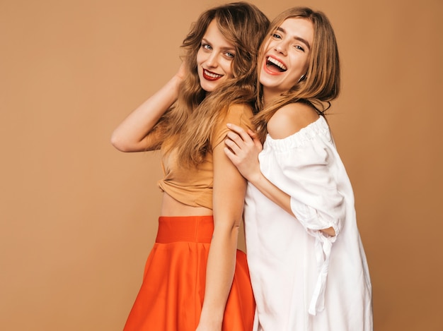 Two young beautiful smiling girls in trendy summer clothes. Sexy carefree women posing. Positive models