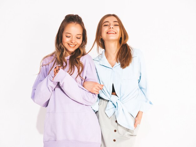 Две молодые красивые улыбающиеся девушки в модной летней одежде. Сексуальные беззаботные женщины. Позитивные модели