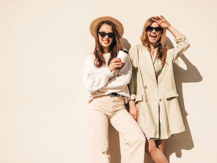 Free Photo two young beautiful smiling hipster female in trendy white sweater and coat