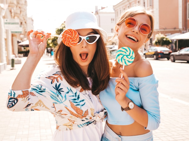 Free photo two young beautiful smiling hipster girls in trendy summer clothes and panama hat.