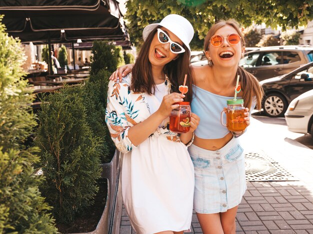 유행 여름 옷과 파나마 모자에 두 젊은 아름 다운 웃는 hipster 여자.