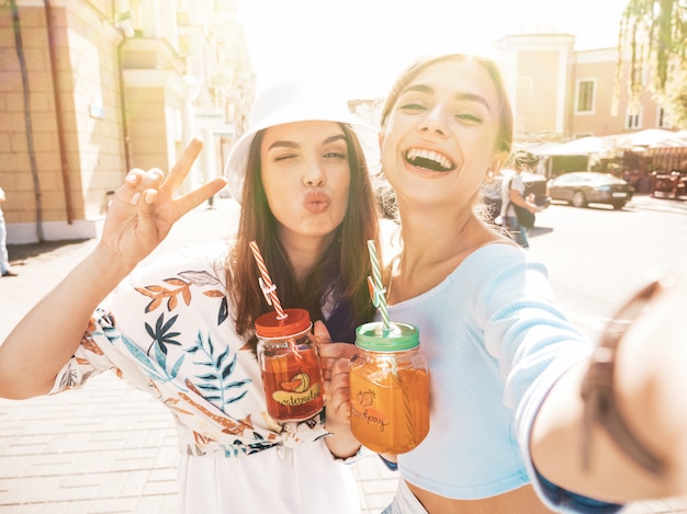 Foto gratuita due giovani belle ragazze sorridenti hipster in abiti estivi alla moda