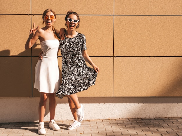 유행 여름 드레스에 두 젊은 아름 다운 웃는 hipster 여자.