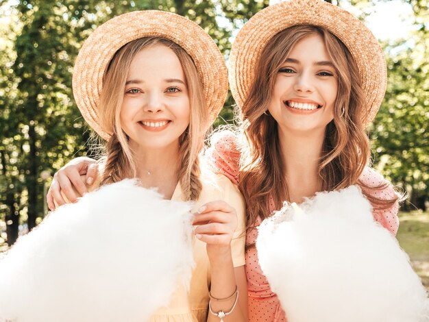 Two young beautiful smiling hipster woman in trendy summer sundress