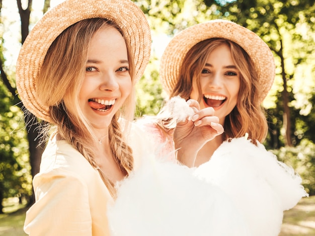 Две молодые красивые улыбающиеся хипстерские женщины в модном летнем сарафане