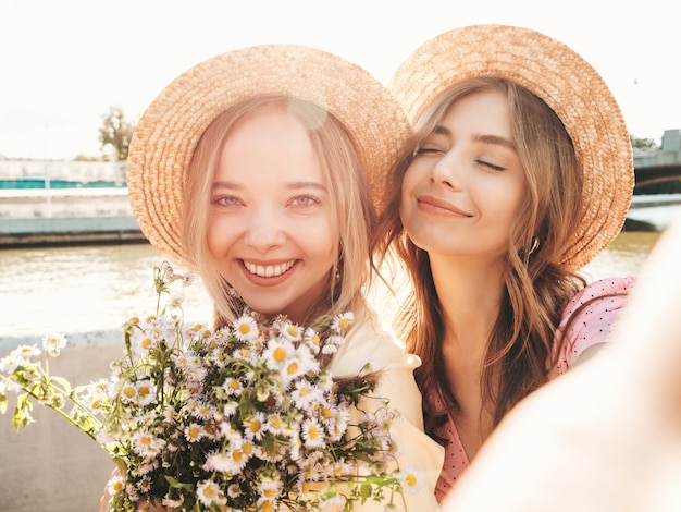 Two young beautiful smiling hipster woman in trendy summer sundress Free Photo