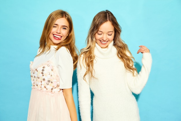 유행 여름 흰 옷에 두 젊은 아름 다운 웃는 hipster 여자. 파란 벽 근처 포즈 섹시 평온한 여자입니다. 긍정적 인 모델