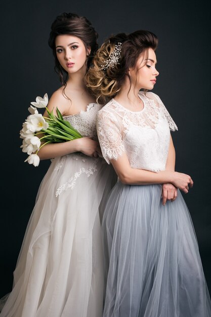 Two young beautiful stylish women in wedding dresses