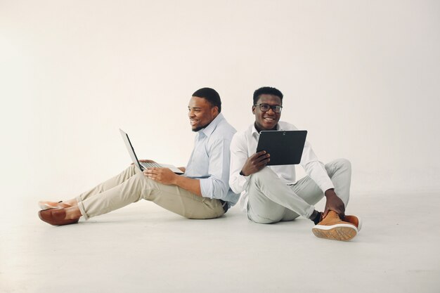 一緒に働く2人の若い黒人男性とラップトップを使用