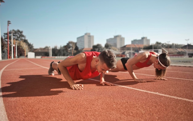 two young boys do push-ups to train on a track