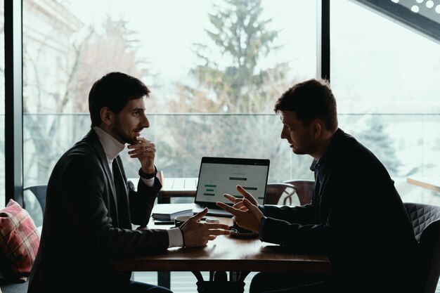 Two young businessman having a successful meeting at restaurant.