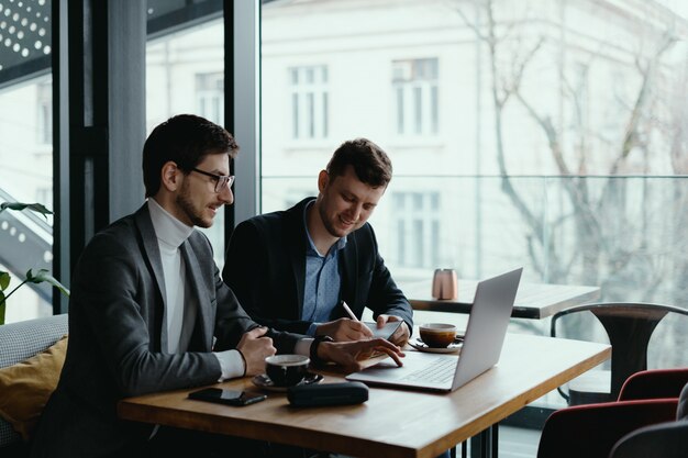 Two young businessman having a successful meeting at restaurant.