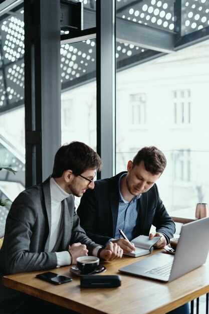 Two young businessman having a successful meeting at restaurant.