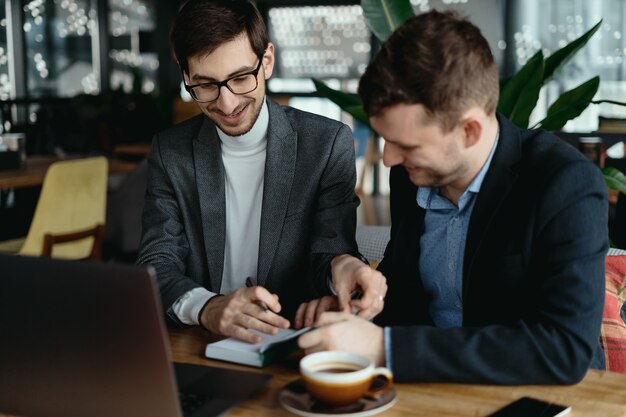 Two young businessman having a successful meeting at restaurant.