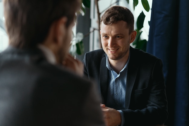 Two young businessmen discussing something