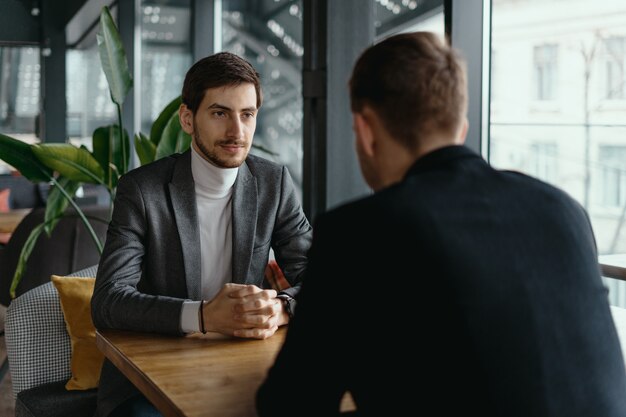 Two young businessmen discussing something