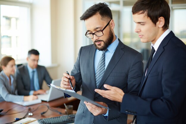 Two young businessmen with a report