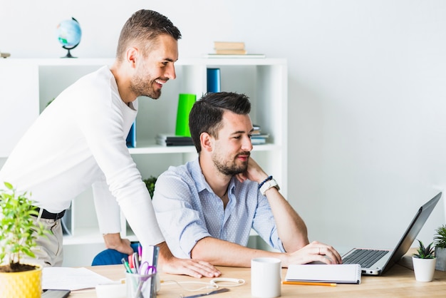 Two young businessmen working on laptop