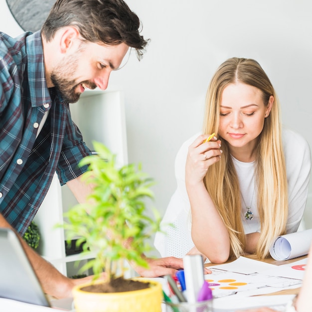 Two young businesspeople analyzing graph