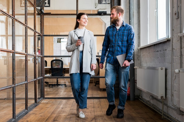 Two young businesspeople walking together in office