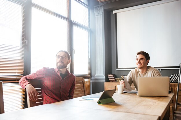 Two young colleagues sitting in office