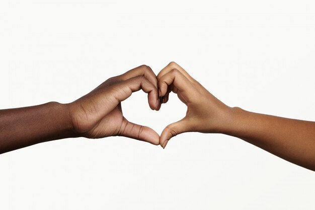 사랑, 평화 및 화합을 상징하는 심장 모양의 손을 잡고 두 젊은 어두운 피부 사람.
