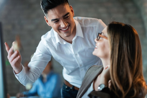 Foto gratuita due giovani imprenditori che comunicano e si divertono al lavoro focus è sull'uomo